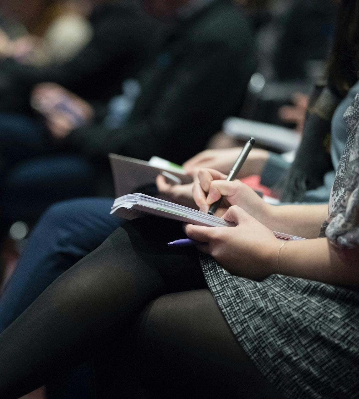 Attendee takes notes at a conference